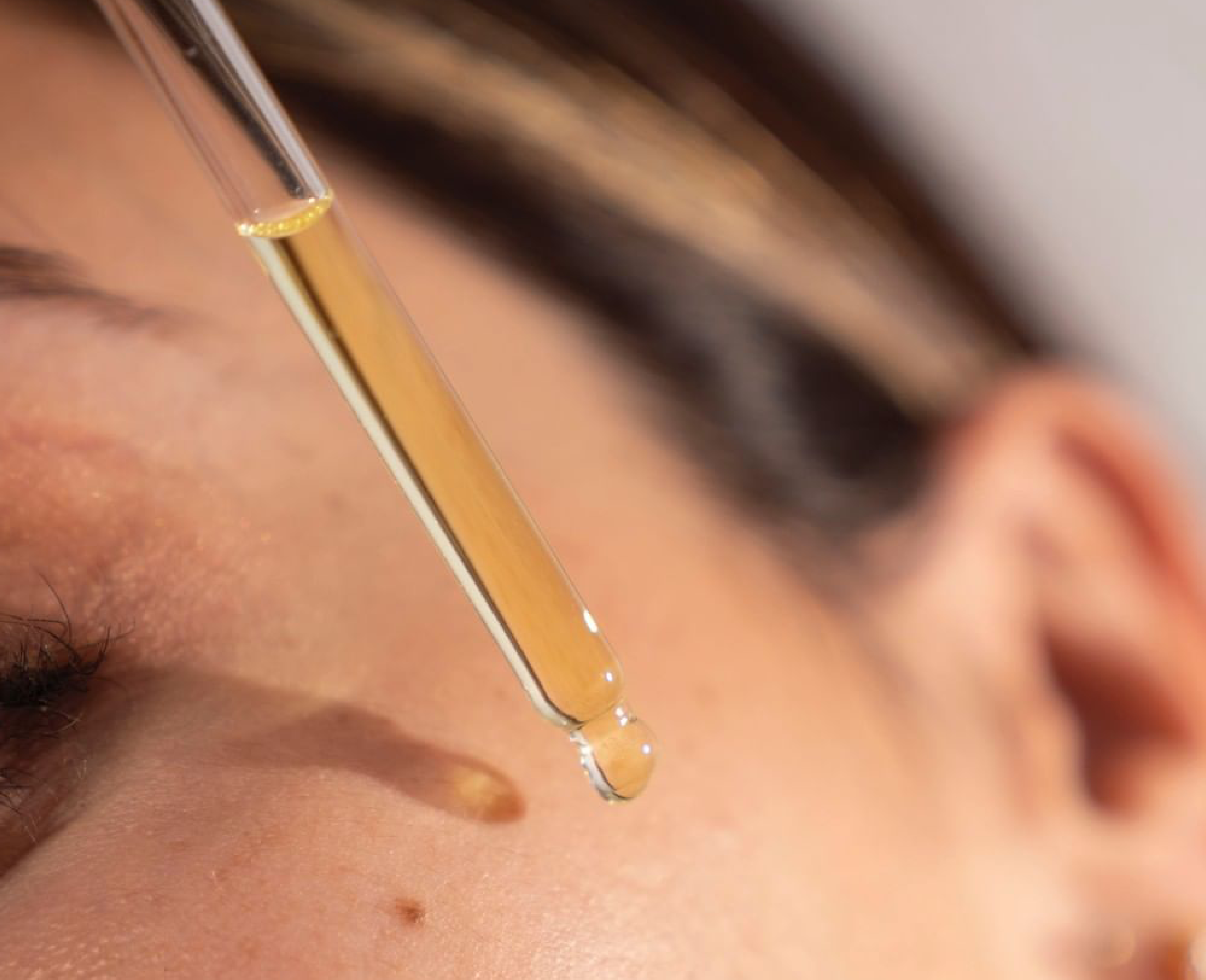 Girl applying O COSMEDICS Retinoic Oil on her skin