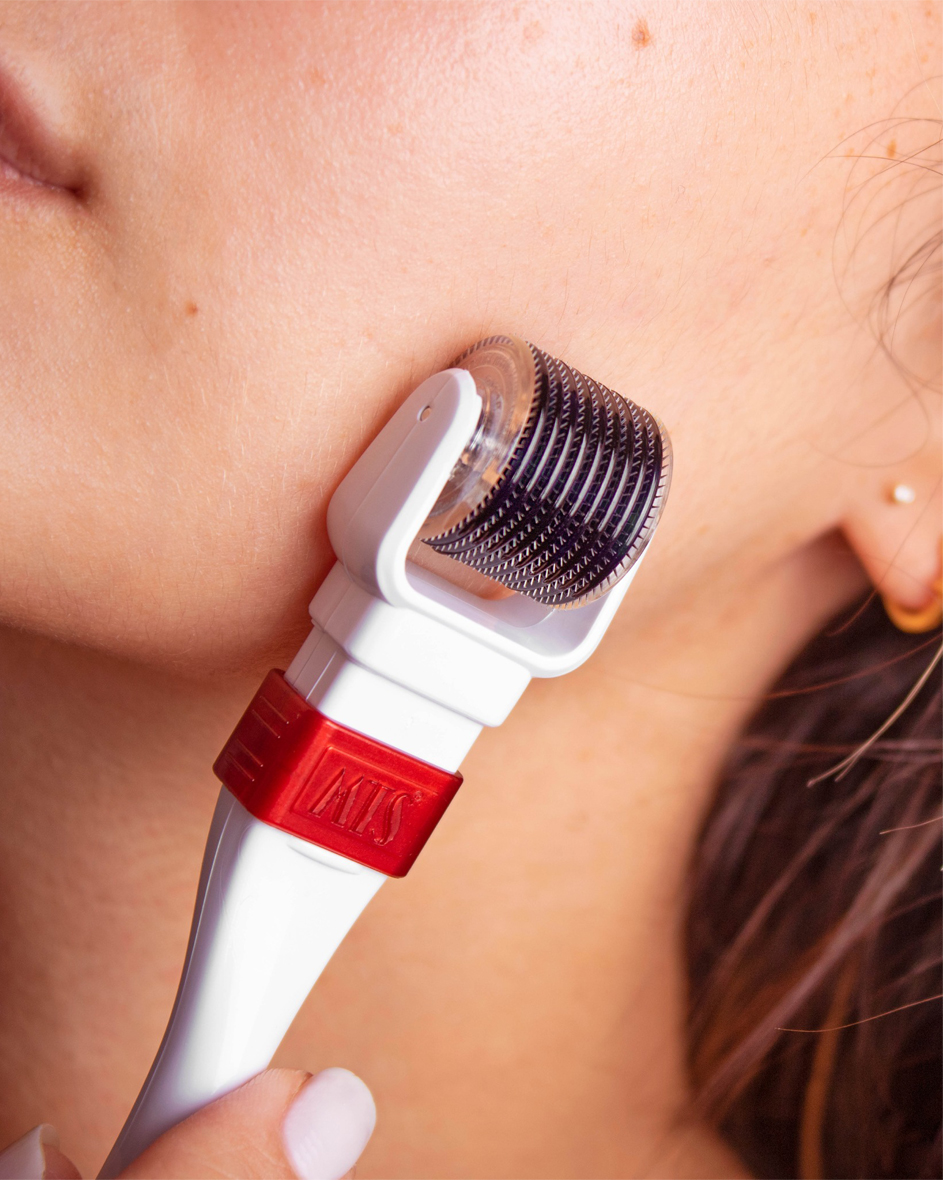 A person using a derma roller to treat the signs of a damaged skin barrier.